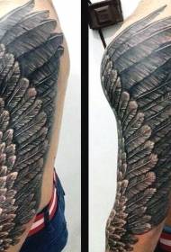 腕の非常に美しい黒と白の鳥の翼のタトゥーパターン