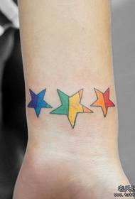 piccolo motivo da tatuaggio a stella a cinque punte colorato da polso da ragazza