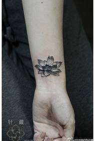 여자의 손목에 아름다운 검은 회색 연꽃 문신 패턴