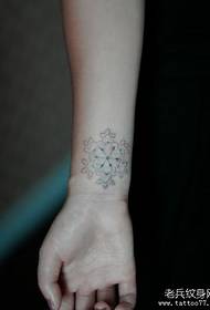 бијели узорак тетоваже сњежне пахуље на зглобу дјевојке