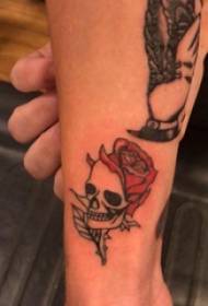 Tatoeages op het kalfje van een kleine jongen op een roos en een tattoo-afbeelding