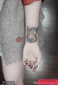 pergelangan tangan seorang wanita Sphinx karya tato kucing dibagi oleh tato