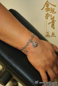 ranne trendikkäässä Tiibetin rannekorun tatuointikuviossa