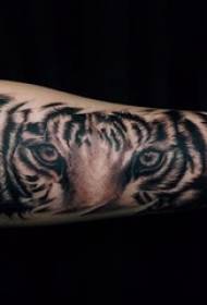 Der Arm des Jungen auf Tier-Tigertätowierungsbild des schwarzen grauen Punktdornenspitzes