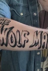 Englisches Tattoo mit Blumenkörper Der Arm eines männlichen Studenten auf einem englischen Tattoo-Bild mit schwarzgrauem Tattoo-Körper