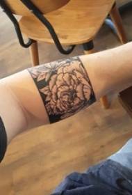 Boy arm op swart punt tattoo geometriese lyn plant blom armband tattoo foto