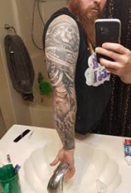 Litterär blommararm tatuerad manlig arm på svart tatuerad bild av blommarmsarm