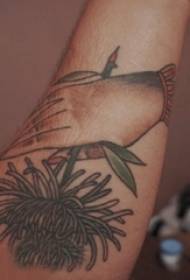 U bracciu di i zitelli picciò nantu à a manu simplice di lignu è pianta di tatuaggi di fiori di pianta