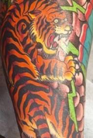 Mutilaren besoa margotutako lorearen besoetan tigrearen tatuaje argazkia