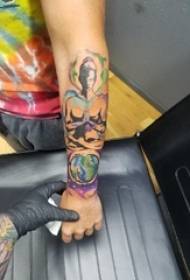 Braccio dello studente maschio del tatuaggio del ritratto del personaggio sulla foto del tatuaggio del ritratto del personaggio e della terra