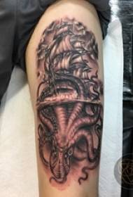 Tatuiruotės juoda berniuko ranka ant aštuonkojo ir burlaivio tatuiruotės paveikslas