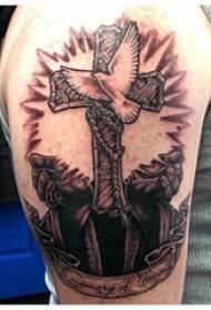 Ръката на момчето върху черно сива точка кръст и бяла гълъб татуировка снимка