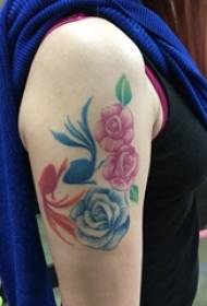 Flickans arm målade på enkla linjer planterar blommor och tatueringsbilder av guldfiskar