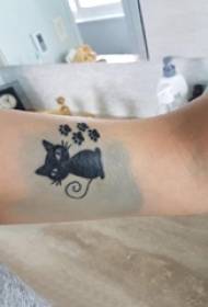 हातावर काळ्या मांजरीचे टॅटू चित्र असलेली लहान ताजी मांजरी टॅटू गर्ल
