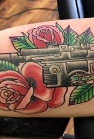 Tatuaxe pistola, brazo masculino, rosa e arma de tatuaxe