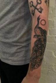 黒い孔雀の入れ墨の写真に孔雀の髪のタトゥーの男性の腕