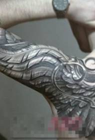男生手臂上黑色素描创意羽毛霸气花臂纹身图片
