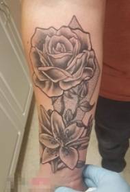 Drengens arm på sort stikket trick blomst tatoveringsbillede