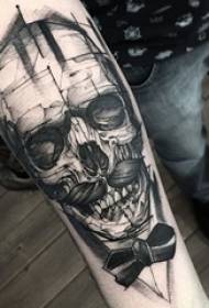 Zēnu roka uz melnas skices radošās personības galvaskausa tetovējuma attēla