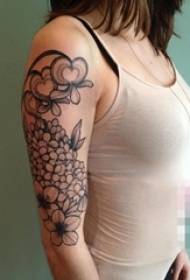 Pigens arm på sort hvidt hortensia og fersken tatoveringsbillede
