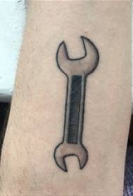 Braccia dei ragazzi sull'immagine nera del tatuaggio dello strumento della chiave inglese di Gray Pointing Geometric Simple Line