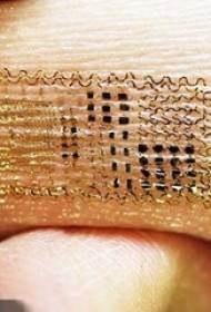 Pigens arm på guldmønster elektronisk tatoveringsbillede