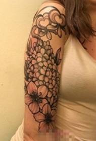 Braccio della ragazza sull'immagine creativa del tatuaggio di amore del modello di fiore di schizzo nero