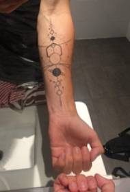 Braccia dei ragazzi sulle linee geometriche nere di personalità semplici Immagine creativa del tatuaggio del pianeta