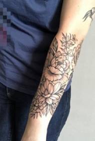 Mergaitės ranka ant juodos pilkos spalvos gėlių grupės tatuiruotės paveikslėlio