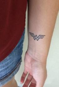 Símbolo de tatuaje brazo de estudiante masculino en imagen de tatuaje de símbolo de mujer maravilla negra