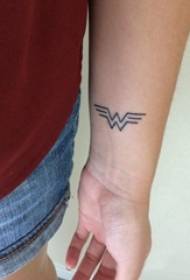 Braccio dello studente maschio di simbolo del tatuaggio sull'immagine nera del tatuaggio di simbolo di wonderwoman