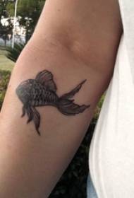 Svart guldfisk tatuering manlig student arm på svart guldfisk tatuering bild