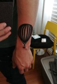 Braccio da scolaro su ancoraggio di linea semplice nera e foto tatuaggio mongolfiera