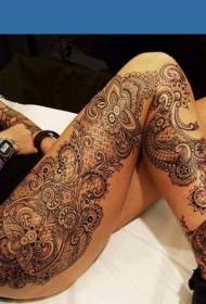 vrouwelijke benen met verbazingwekkend ontworpen totem decoratieve tattoo met bloemenprint