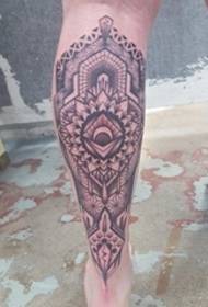 Juodas intensyvaus geometrinio mandalos tatuiruotės paveikslėlis ant blauzdos