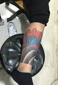 Il modello del tatuaggio del loto color polpaccio è molto accattivante