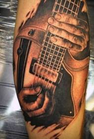 Musicista realistu di vitellu chì tocca u mudellu di tatuaggi di chitarra