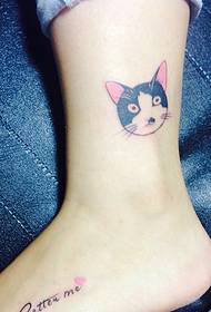 Mažos katės galvos tatuiruotė, gulinti ant balto blauzdos