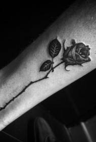 Motivo a tatuaggio con rosa spinato sulle gambe
