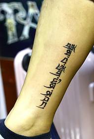 Tatuaggio sanscrito semplice di vitello molto poco appariscente