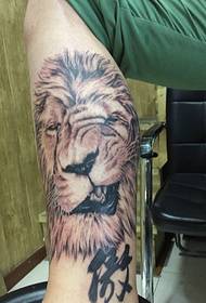 Черно-белая татуировка головы льва на икре очень страшная