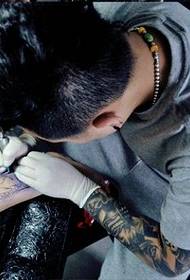 Tatuisto-artisto tiklas en la bovido