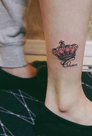 un mini tatuaggio a forma di corona sul polpaccio