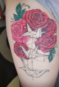 Udo dziewczyny z tatuażem kwiatowym na tysiącu papierowych żurawi i tatuaży róż