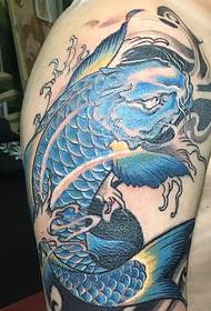 Blauwe grote inktvis tatoeage die op de grote arm valt