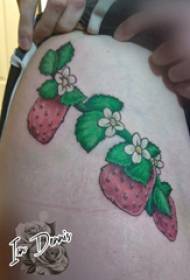 Coscia della ragazza del tatuaggio dell'alimento sull'immagine colorata del tatuaggio della fragola
