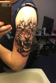 Tattoo pricking technyk manlike tijter dij op swarte tiger tatoeage foto