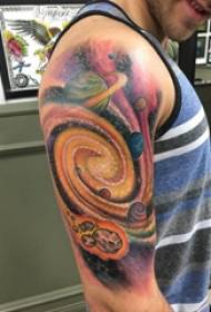Tattoo ဂြိုလ်သားသည်စကြာ ၀ withာကြီး၏လက်၌ကြီးမားသောလက်မောင်းဖြင့်တက်တူးထိုးထားသည်