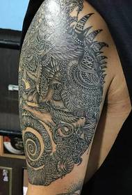 Bardzo fajny tatuaż totemowy na dużym ramieniu
