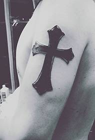 Stampa tatuata di croce di a personalità cù u bracciu maiò di l'omi